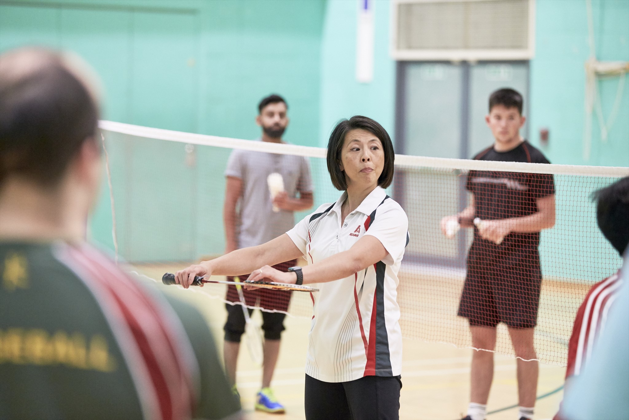 Female coach training male badminton players