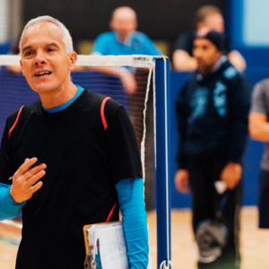 Introduction to eLearning from Badminton England. Male coach by net.