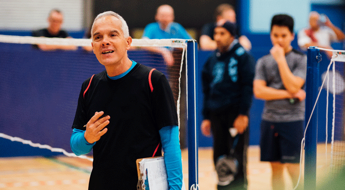 Introduction to eLearning from Badminton England. Male coach by net.